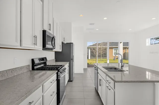 a kitchen with stainless steel appliances granite countertop a sink stove and cabinets