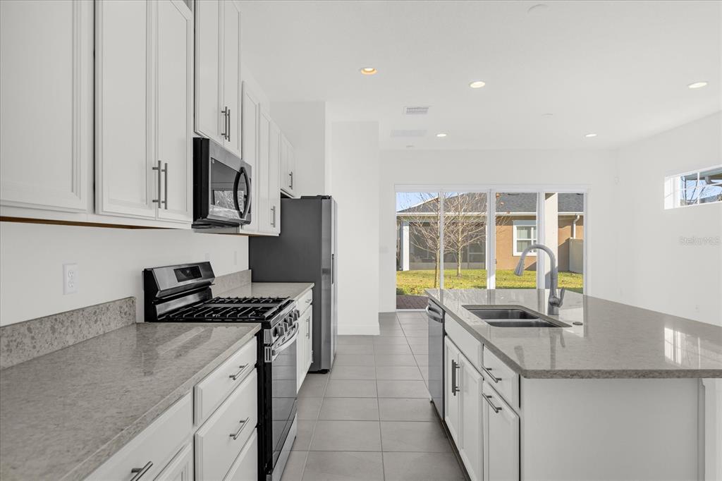 2360 Datura Loop St. Cloud, FL 34772 - Photo 8 of 46 a kitchen with stainless steel appliances granite countertop a sink stove and cabinets