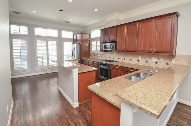 a kitchen with stainless steel appliances granite countertop sink stove top oven and cabinets