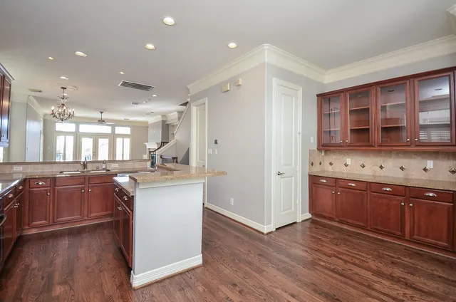 a large kitchen with stainless steel appliances granite countertop a large stove a sink dishwasher and a refrigerator with wooden floor