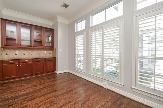 a kitchen with stainless steel appliances wooden floor and a large window