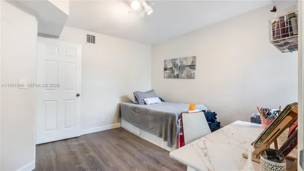 a bedroom with two beds and a book shelf