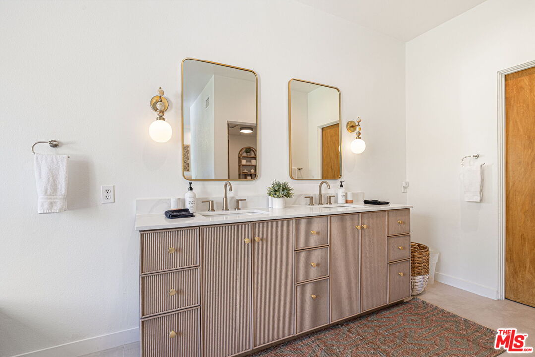 1414 Sagebrush Road Palm Springs, CA 92264 - Photo 36 of 48 a spacious bathroom with a double vanity sink and mirror