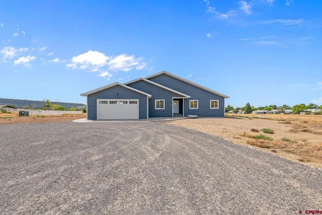 a view of a house with a yard and large tree