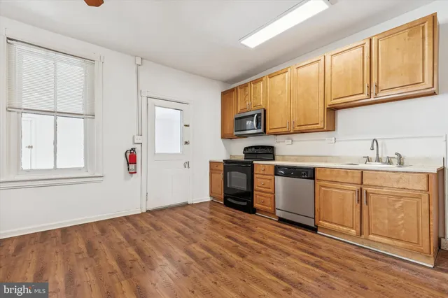 a kitchen with granite countertop white cabinets and wooden floor