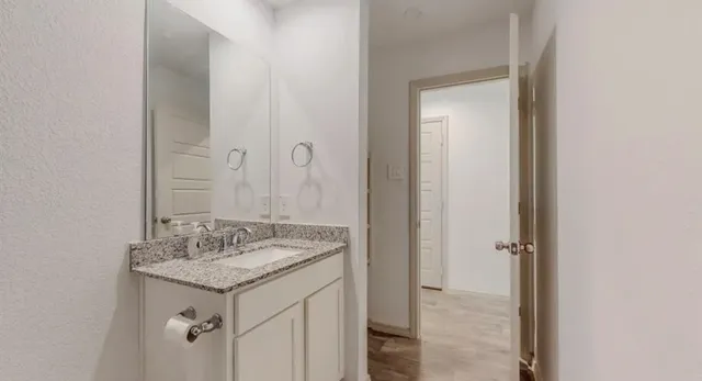a bathroom with a granite countertop sink and a mirror