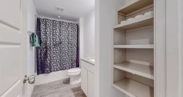a bathroom with a toilet and a shower curtain