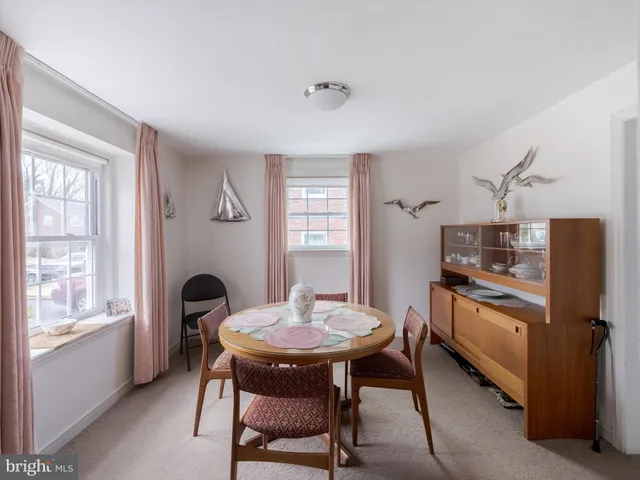 a kitchen with stainless steel appliances granite countertop a dining table chairs and a refrigerator