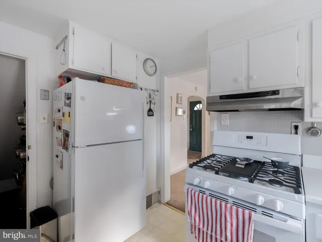 a white refrigerator freezer and a stove sitting inside of a kitchen