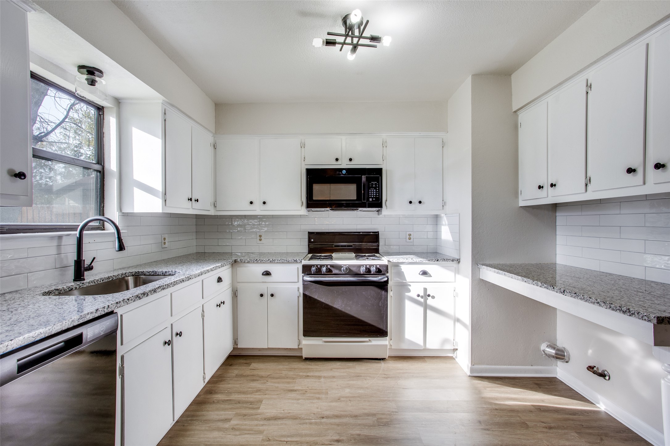 2212 Rifle Bend Drive Georgetown, TX 78626 - Photo 5 of 15 a kitchen with granite countertop a stove top oven sink and cabinets