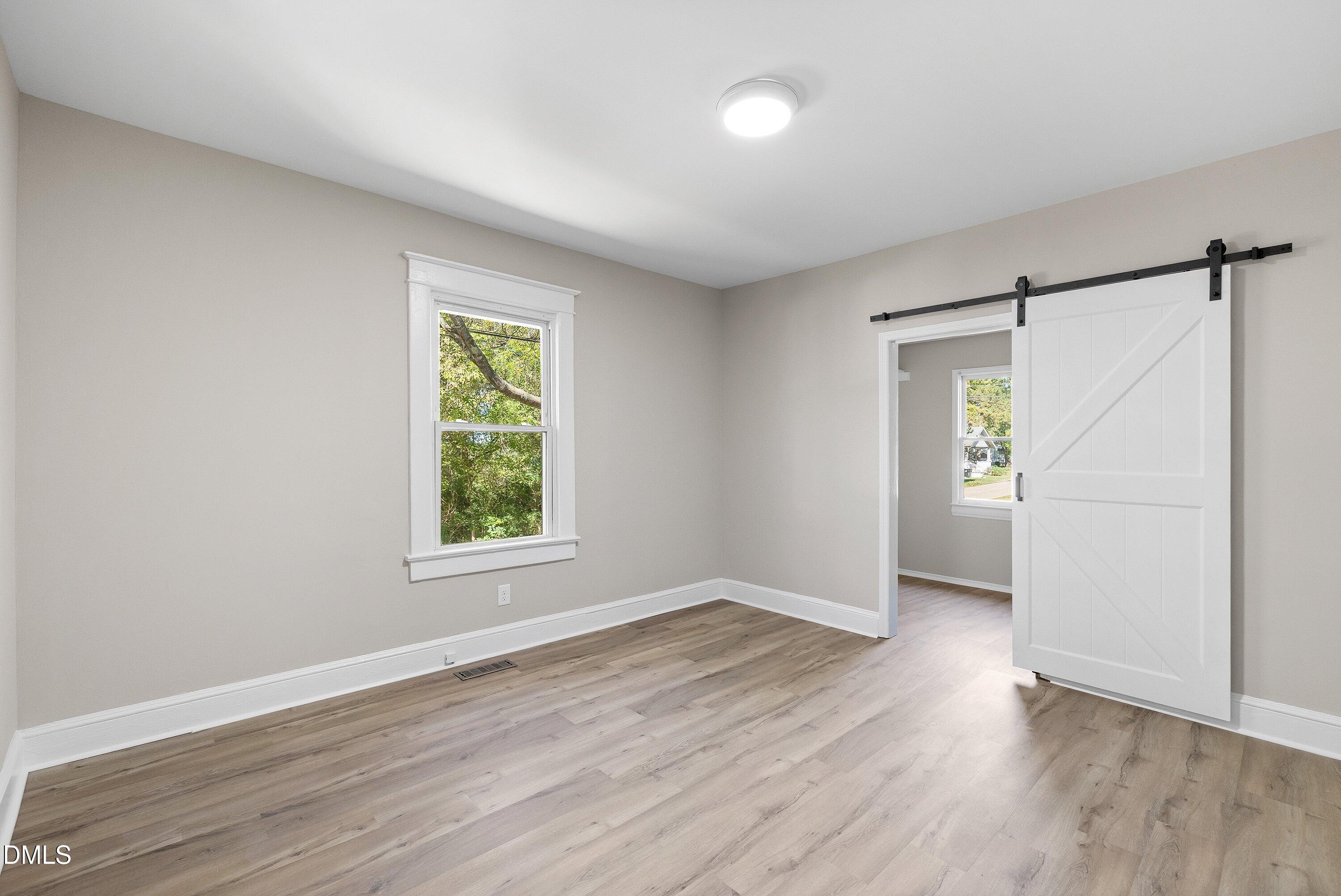 411 West I Street Erwin, NC 28339 - Photo 14 of 28 an empty room with wooden floor and windows
