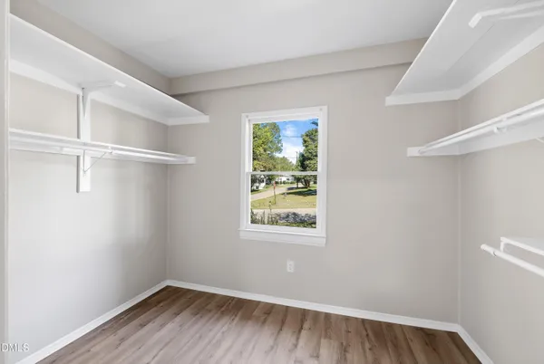a view of a room with wooden floor closet and windows
