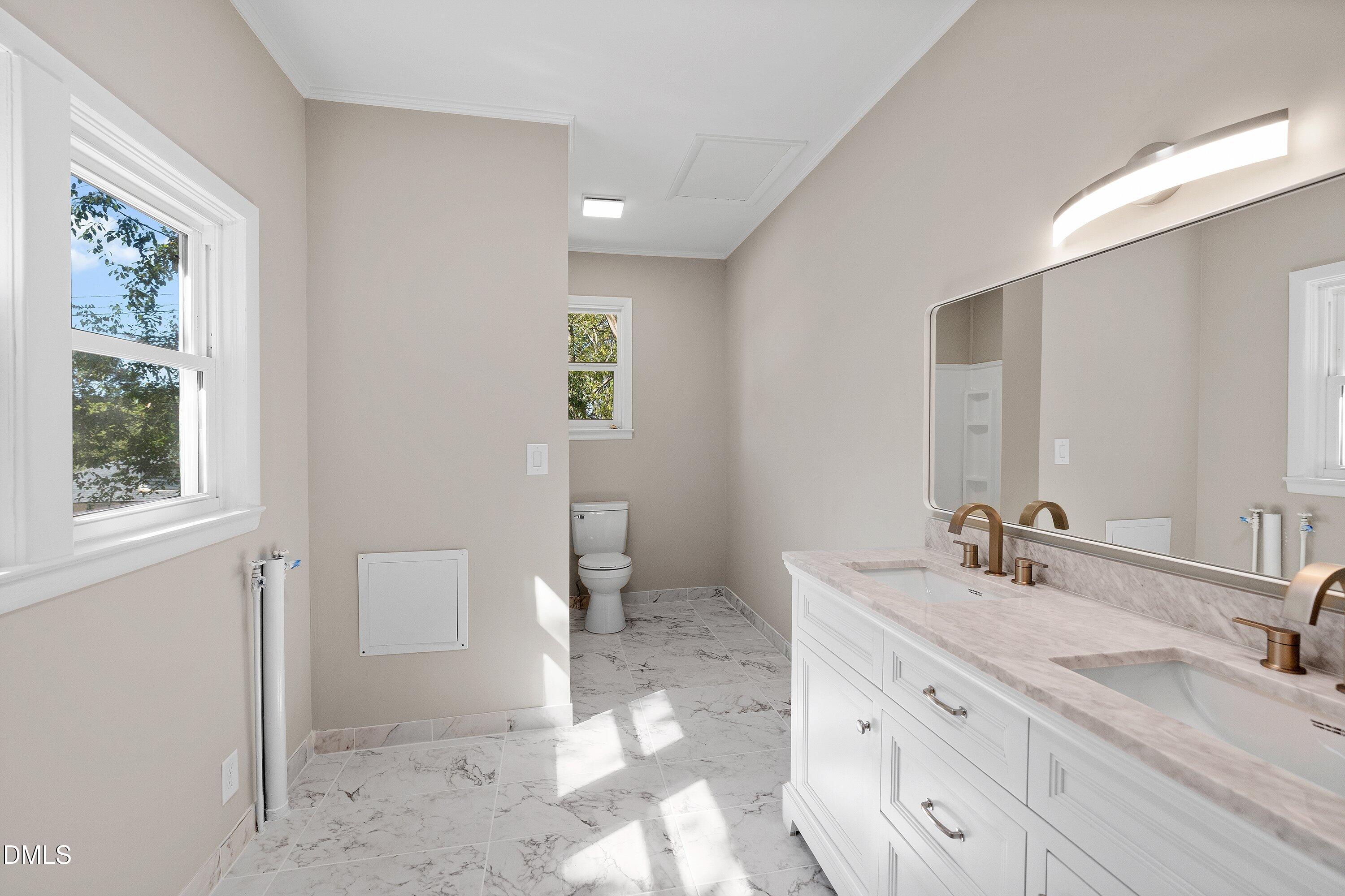 411 West I Street Erwin, NC 28339 - Photo 17 of 28 a bathroom with double vanity sink a mirror and a toilet
