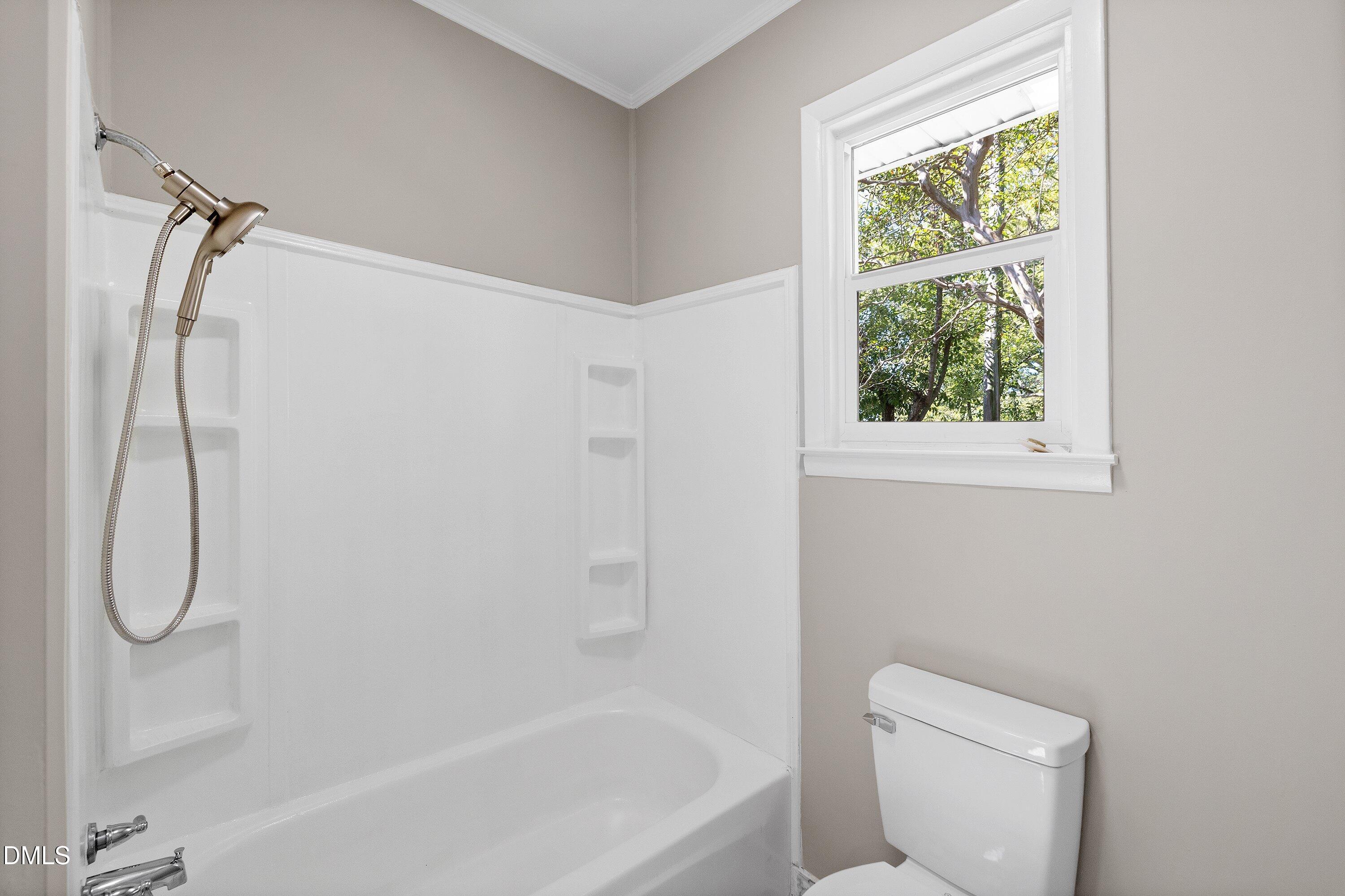 411 West I Street Erwin, NC 28339 - Photo 19 of 28 a bathroom with a toilet and a bathtub