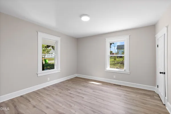 an empty room with wooden floor and a window