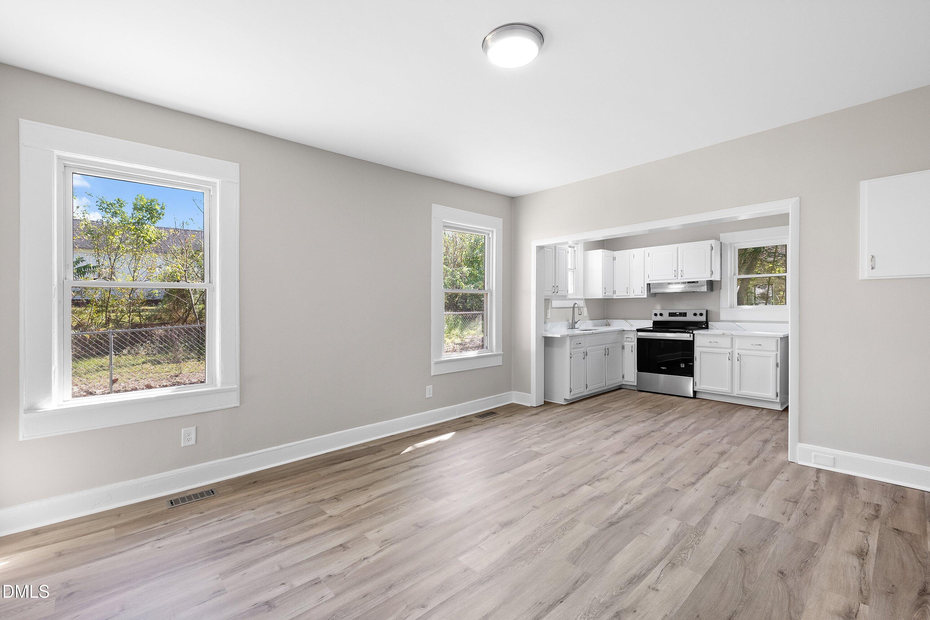 411 West I Street Erwin, NC 28339 - Photo 7 of 28 an empty room with wooden floor and windows