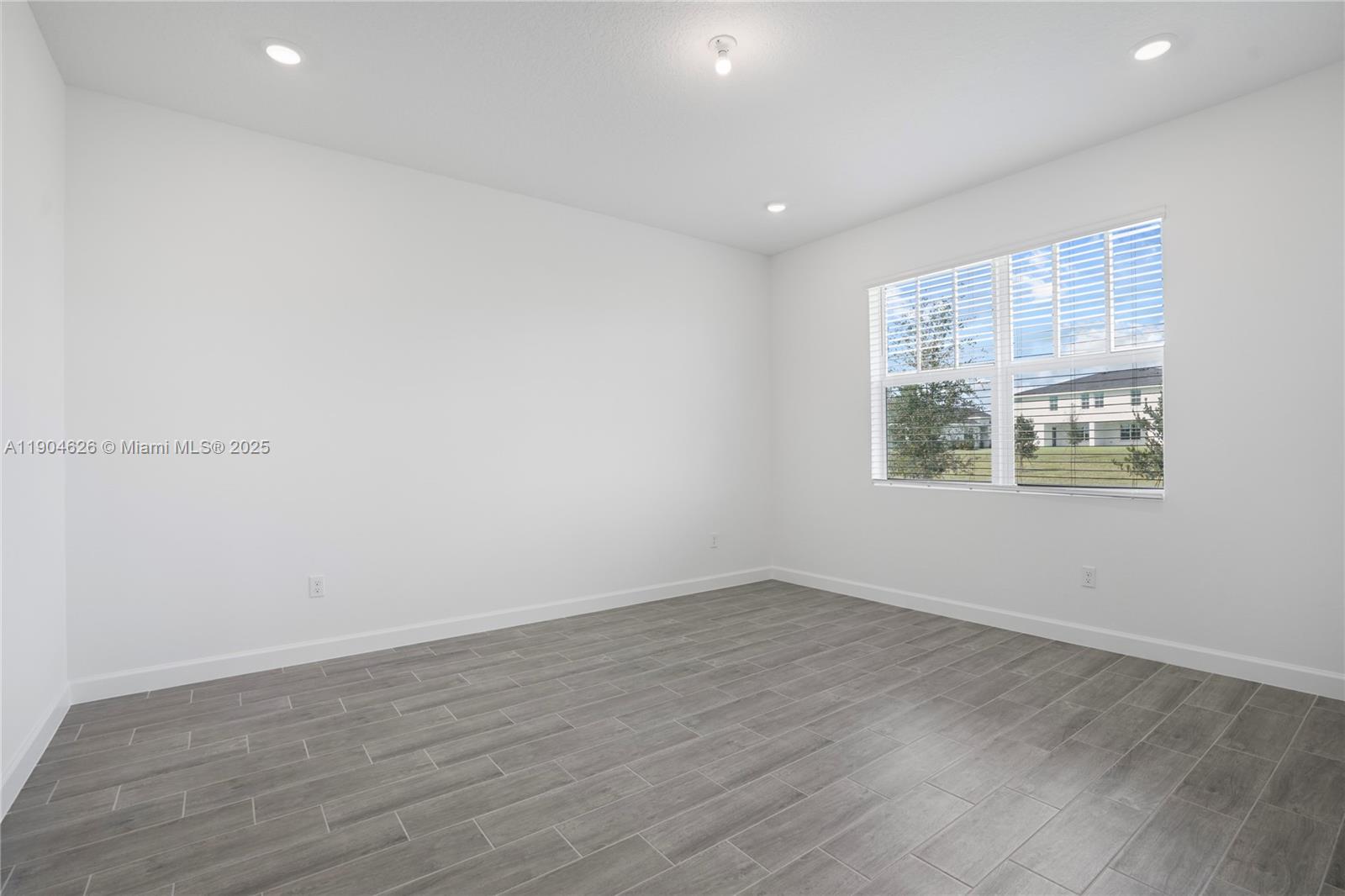 19655 Barn Swallow Way, Unit 19655 West Palm Beach, FL 33470 - Photo 16 of 59 an empty room with wooden floor and window