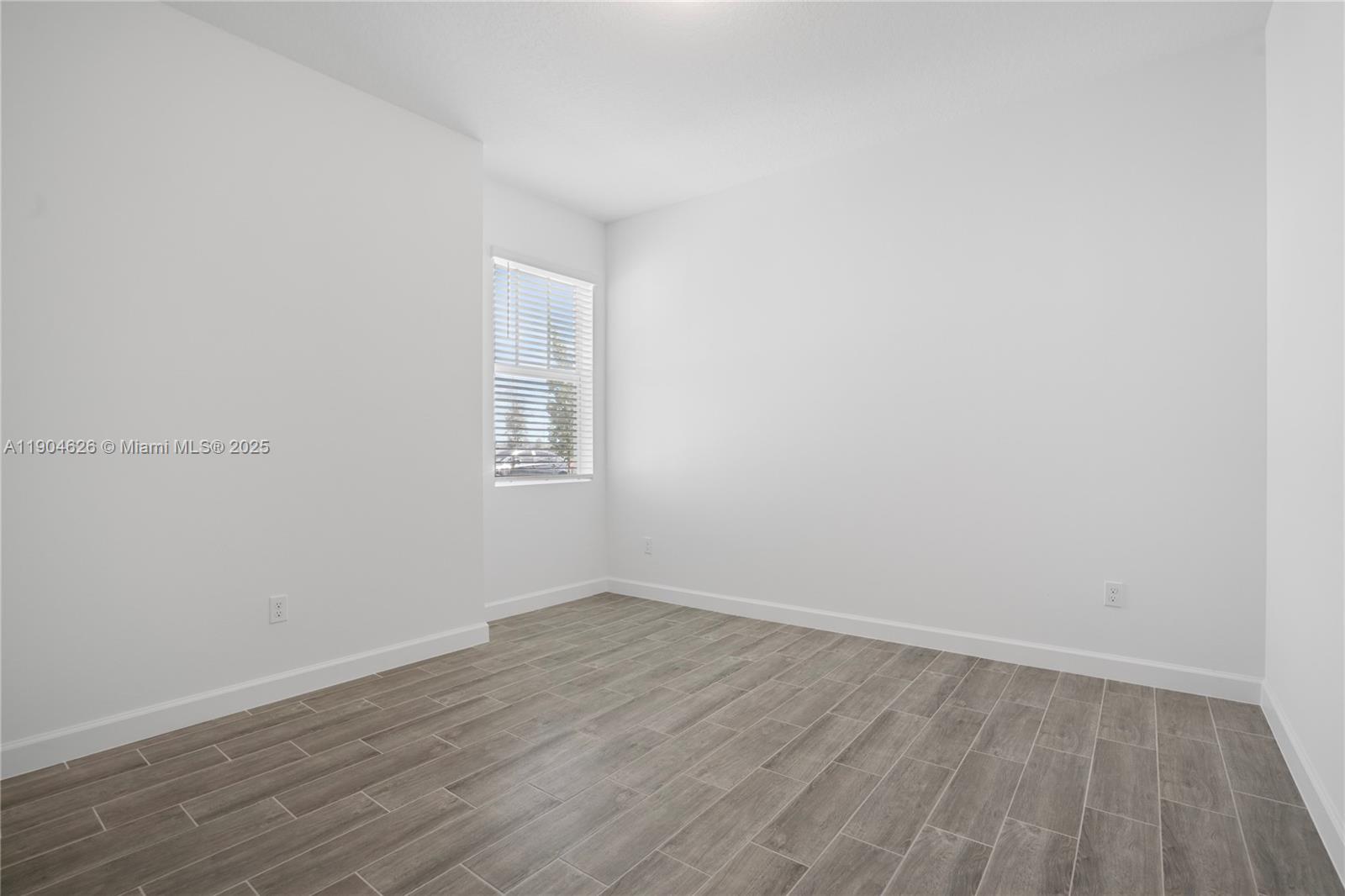 19655 Barn Swallow Way, Unit 19655 West Palm Beach, FL 33470 - Photo 21 of 59 a view of an empty room with wooden floor and a window