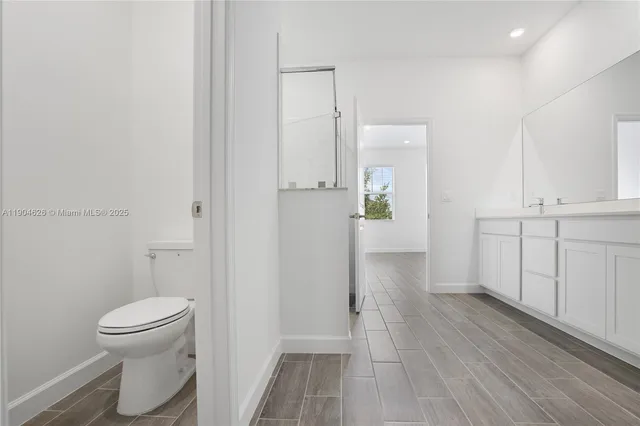 a white toilet sitting next to a white wall