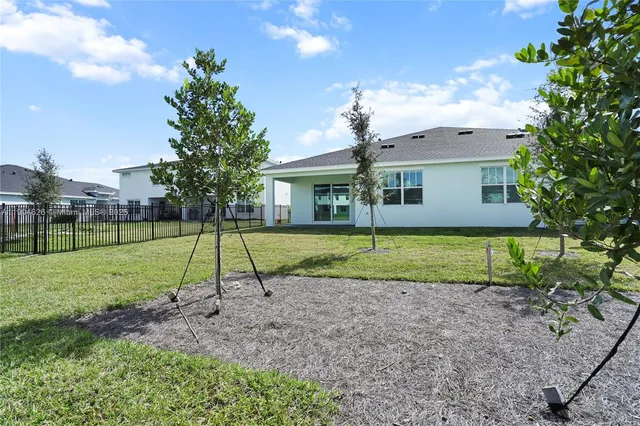 a view of a house with a yard and potted plants