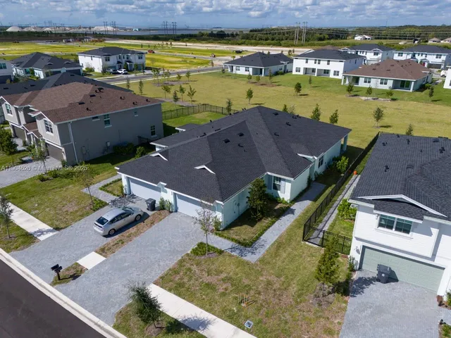 an aerial view of residential houses with outdoor space and swimming pool
