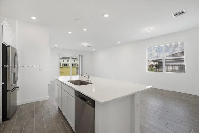 a kitchen with stainless steel appliances a refrigerator stove microwave and sink