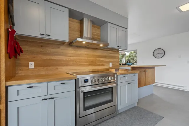 a large kitchen with stainless steel appliances granite countertop a lot of counter top space and cabinets