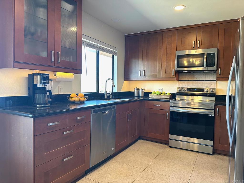 4253 Fifth Avenue San Diego, CA 92103 - Photo 6 of 22 a kitchen with granite countertop wooden cabinets stainless steel appliances and a window