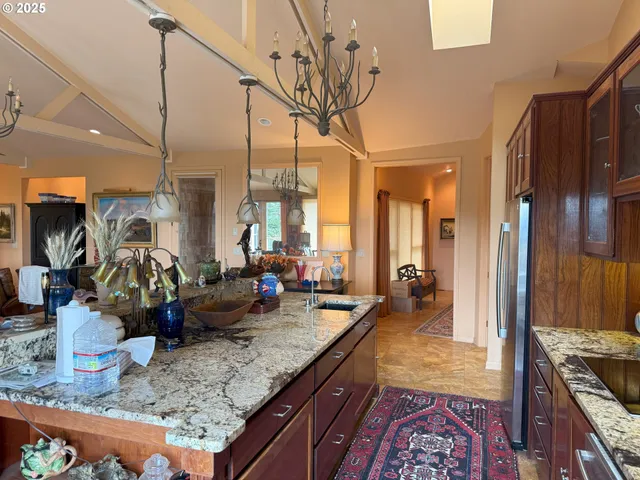 a large kitchen with kitchen island granite countertop a large counter top and stainless steel appliances