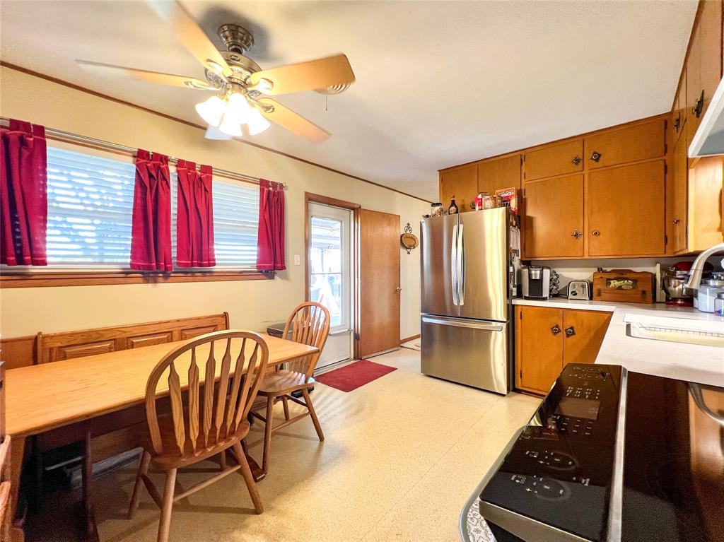 1009 North 7th Street Haskell, TX 79521 - Photo 12 of 26 a kitchen with a refrigerator a stove a sink dishwasher with a dining table and chairs