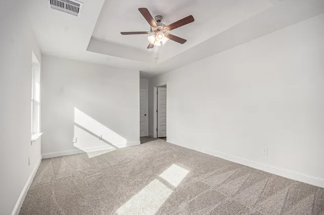 an empty room with ceiling fan and entryway