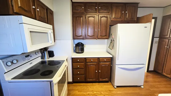 a kitchen with stainless steel appliances granite countertop a refrigerator a stove and a sink with wooden cabinets