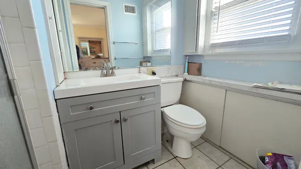 a bathroom with a sink toilet and a window