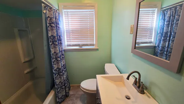 a bathroom with a sink a toilet and a window