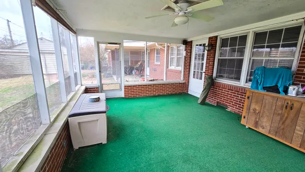 a view of a porch with furniture and a yard