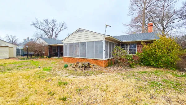 a view of a house with a backyard and sitting area