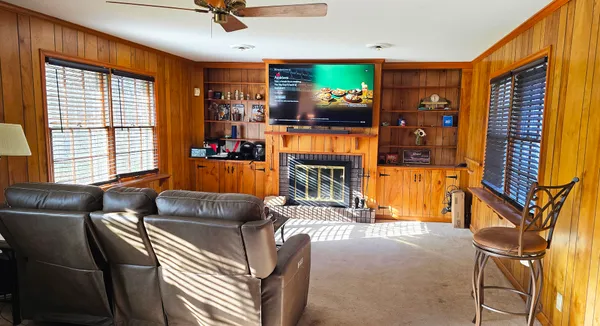 a living room with furniture a flat screen tv and a window