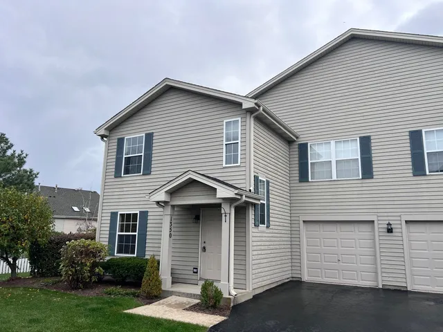 a view of a white house with a yard and garage