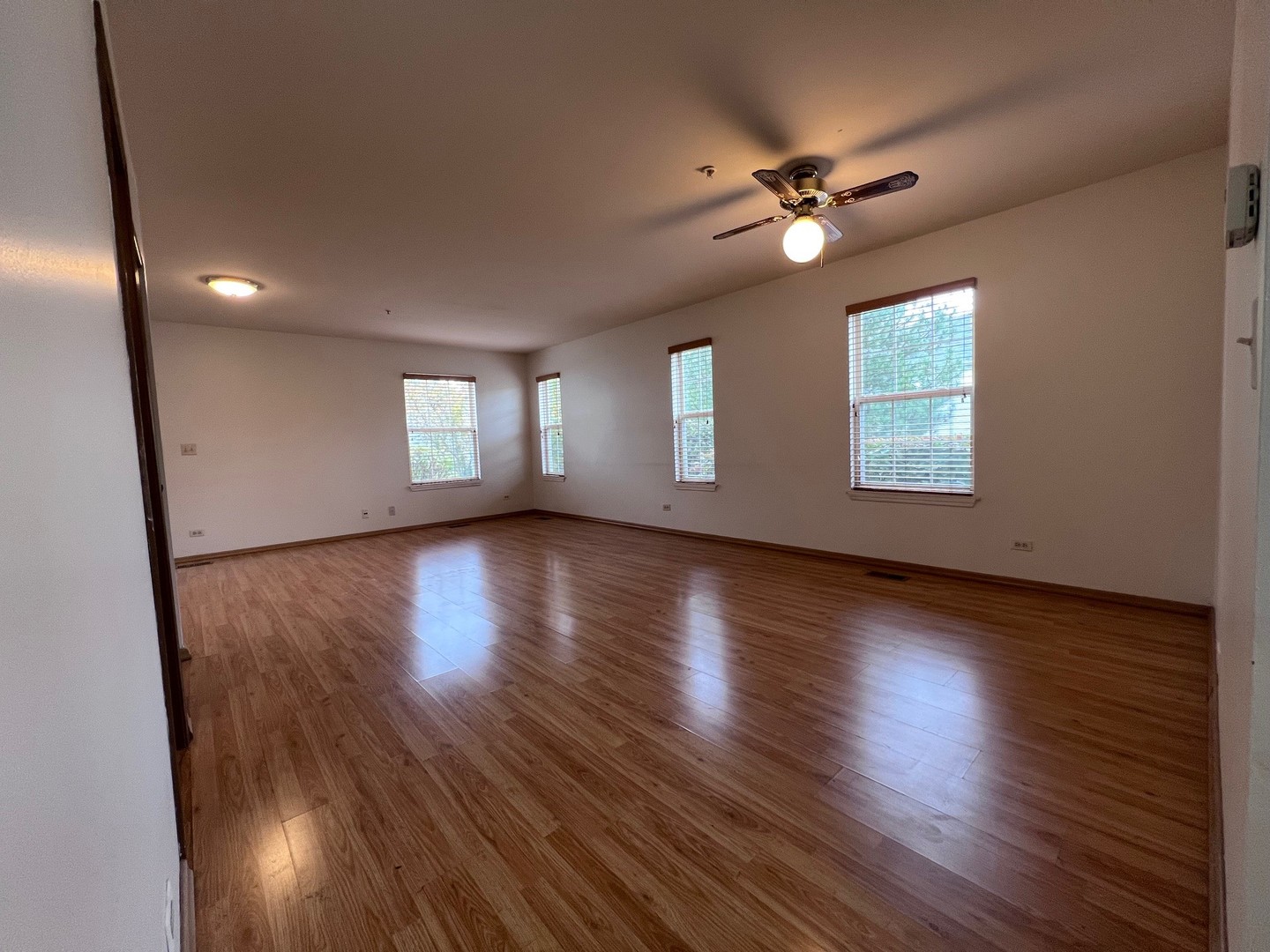 1350 Orleans Drive, Unit 1350 Mundelein, IL 60060 - Photo 13 of 26 a view of an empty room with wooden floor and a window