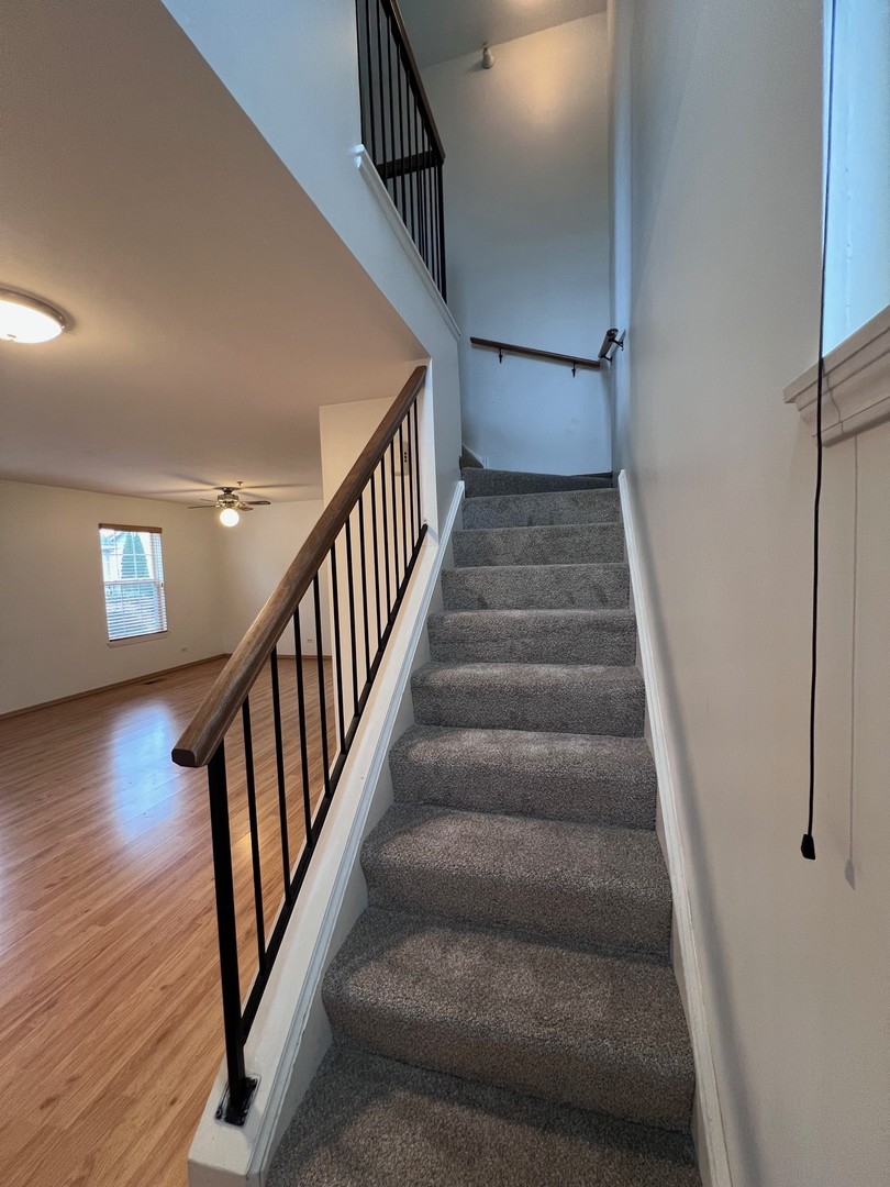 1350 Orleans Drive, Unit 1350 Mundelein, IL 60060 - Photo 14 of 26 a view of staircase with wooden floor and fan
