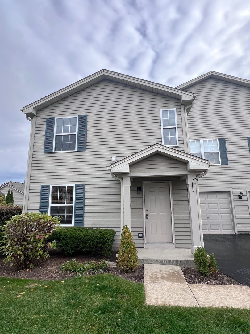 1350 Orleans Drive, Unit 1350 Mundelein, IL 60060 - Photo 5 of 26 a front view of a house with a garden and plants