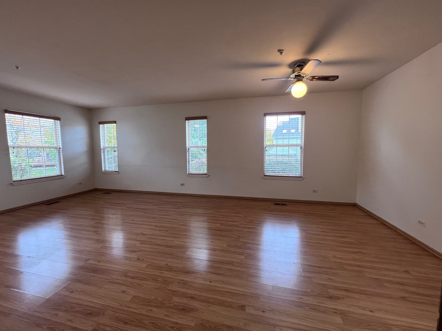 1350 Orleans Drive, Unit 1350 Mundelein, IL 60060 - Photo 10 of 26 an empty room with wooden floor and windows