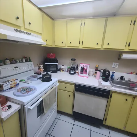 a kitchen with a sink a stove cabinets and a window