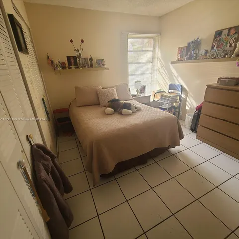 a bedroom with a bed and a dresser next to a window