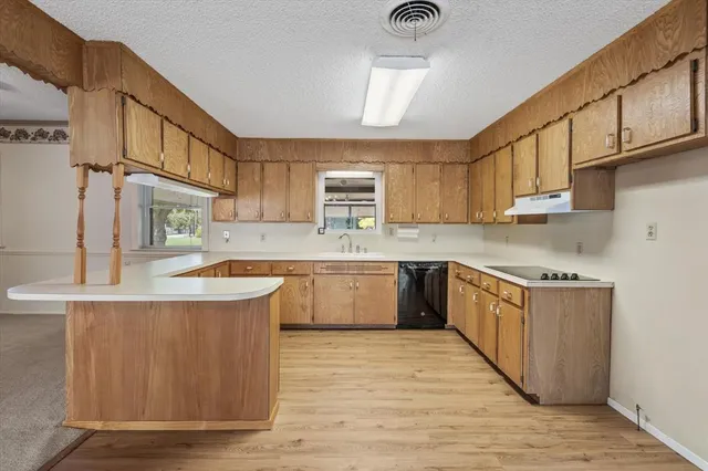a kitchen with granite countertop a sink a stove and cabinets