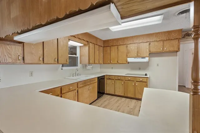 a kitchen with granite countertop a refrigerator and a stove top oven