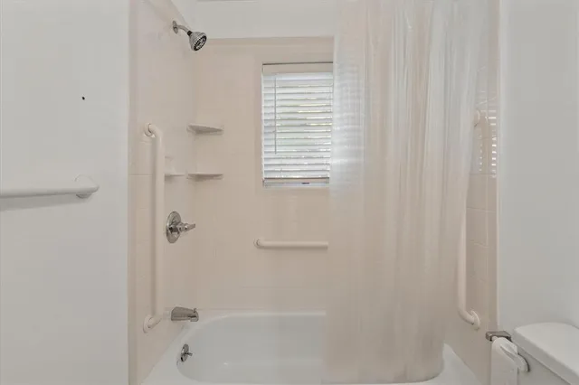 a view of a livingroom with a ceiling fan & kitchen view