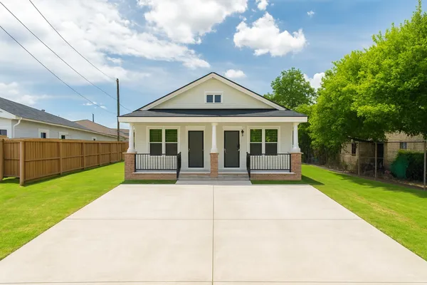 a view of house that has a big yard and large trees