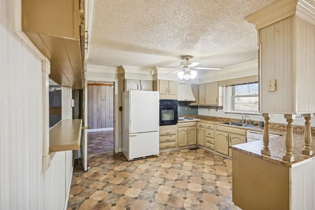 a large kitchen with a stove a refrigerator and a stove top oven
