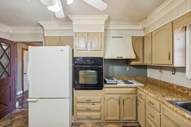 a kitchen with stainless steel appliances granite countertop a refrigerator sink and white cabinets